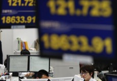 Employees of a foreign exchange trading company work under monitors in Tokyo